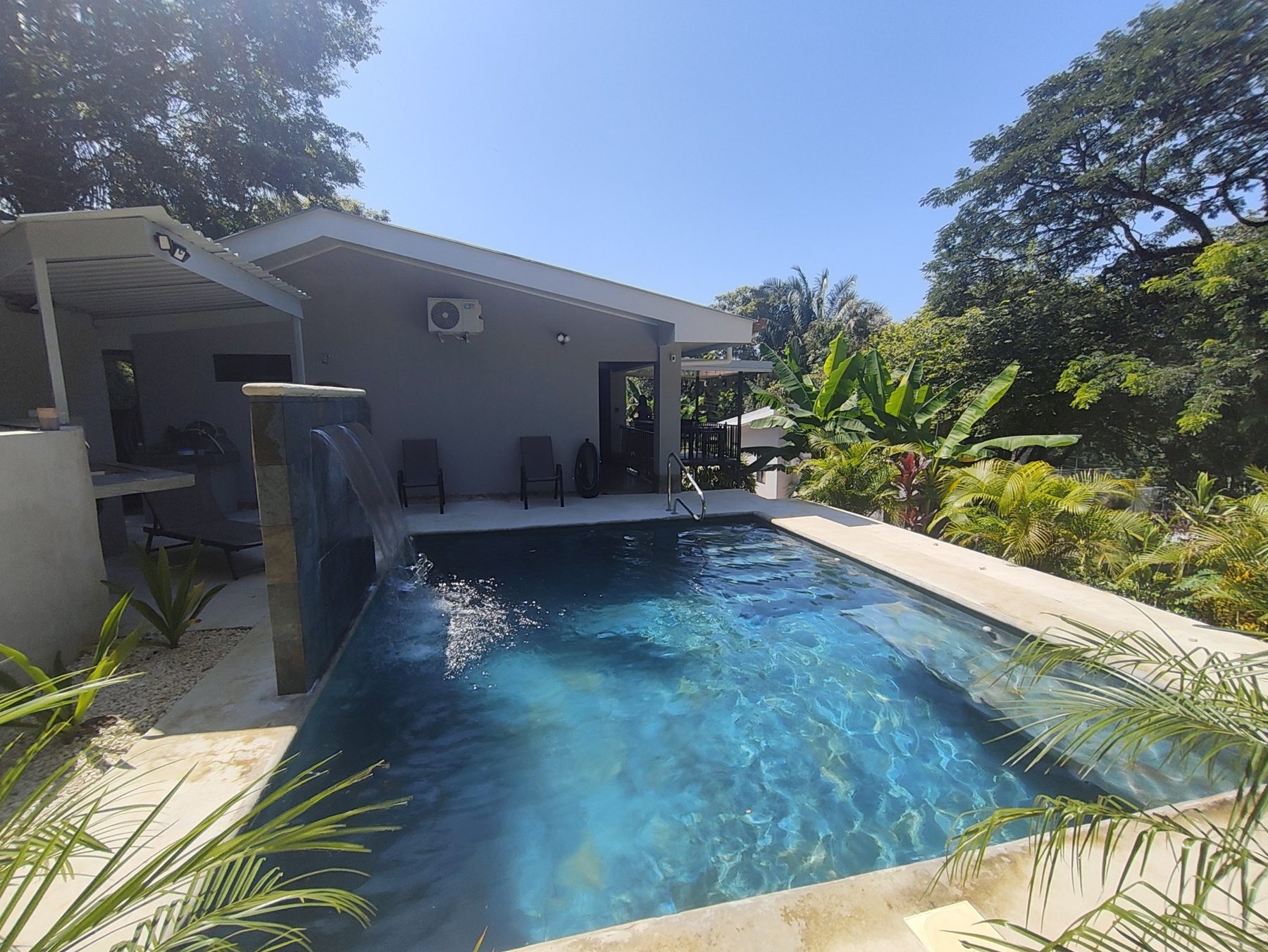 Private pool with waterfall and the house behind